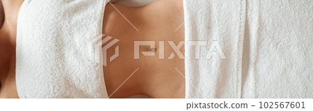 Fit young woman lying on massage table in spa salon Fit young woman lying on massage table in spa salon 102567601