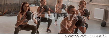 Professional trainer with his clients in gym Professional trainer with his clients in gym 102568142