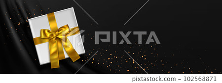 3d gift box with gold ribbon on black silk fabric 102568871