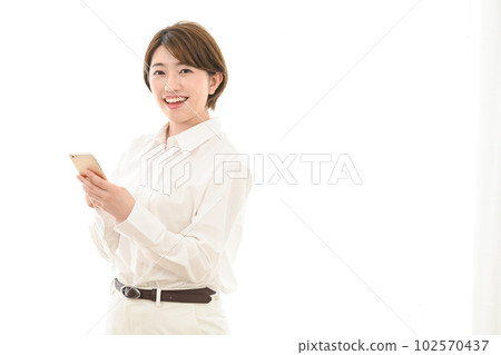 A woman watching a smartphone at the window side A woman watching a smartphone at the window side 102570437