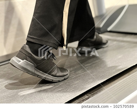 Feet walking on a running machine Feet walking on a running machine 102570589