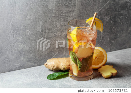 Iced tea with mint, ginger, and lemon on a grey background. 102573781