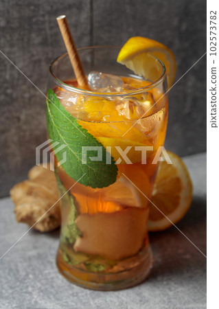Iced tea with mint, ginger, and lemon on a grey background. 102573782