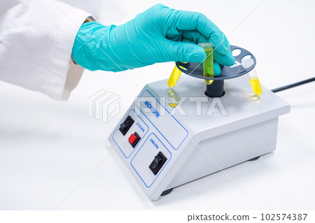 Scientist puts test tube to micro spin for phase separation for microbiological analysis Scientist puts test tube to micro spin for phase separation for microbiological analysis 102574387