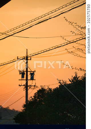 黃色朦朧的天空和日落時建築物的輪廓 102575780