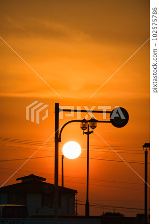 The yellow hazy sky and the silhouette of the building at sunset The yellow hazy sky and the silhouette of the building at sunset 102575786
