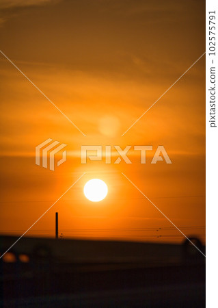 The yellow hazy sky and the silhouette of the building at sunset 102575791