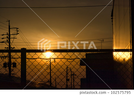 The yellow hazy sky and the silhouette of the building at sunset The yellow hazy sky and the silhouette of the building at sunset 102575795