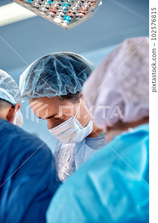 Faces of surgeons close-up during a complex and intense operation, doctors save the patient's life, teamwork of surgeons Faces of surgeons close-up during a complex and intense operation, doctors save the patient's life, teamwork of surgeons 102576815