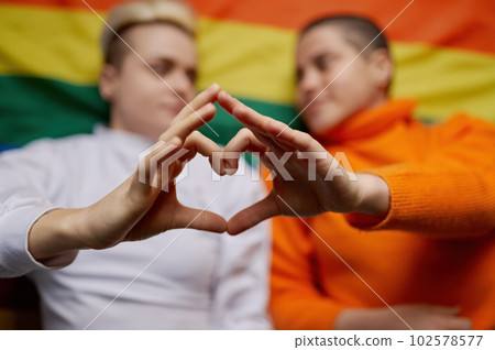 Selective focus on lesbian woman couple gesturing heart sign with hands 102578577