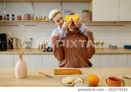 Overjoyed LGBTQ couple woman lovers fooling around while preparing dinner 102578582