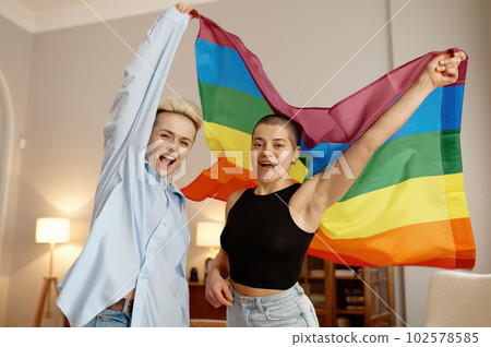 Young LGBTQ couple lovers feeling proud and preparing for tolerance parade show Young LGBTQ couple lovers feeling proud and preparing for tolerance parade show 102578585