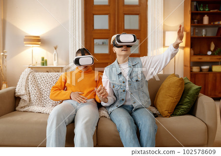 Young lesbian woman couple wearing vr goggles playing video game Young lesbian woman couple wearing vr goggles playing video game 102578609