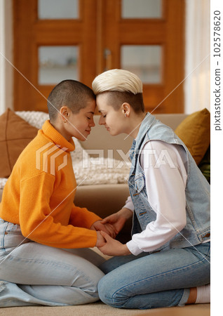 Romantic lesbian woman couple feeling love holding each other hands Romantic lesbian woman couple feeling love holding each other hands 102578620