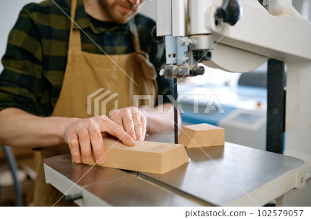 Carpenter using band saw to cut plywood, closeup shot with selective focus Carpenter using band saw to cut plywood, closeup shot with selective focus 102579057