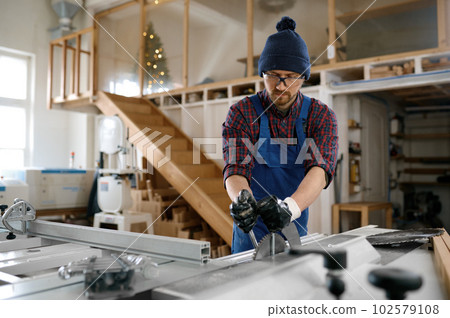 Carpenter hand changing saw blade for woodworking 102579108