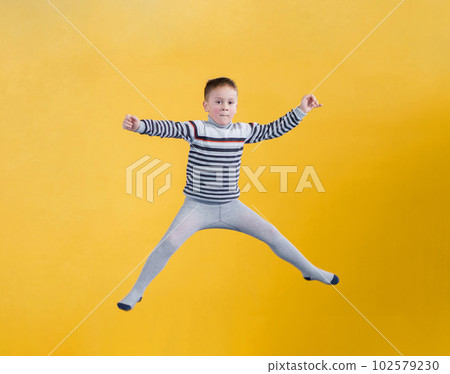 Happy boy jumping on yellow background Happy boy jumping on yellow background 102579230