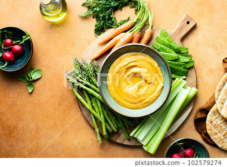 Chickpea hummus served with spring vegetables 102579274