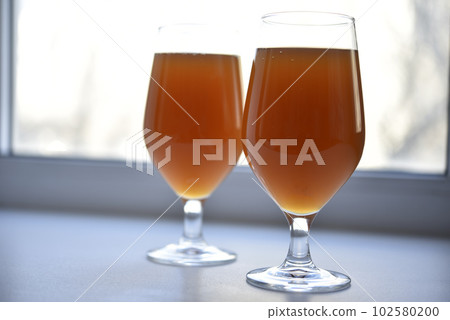 Beer glass on a white background. Beer on the windowsill. Beer glass on a white background. Beer on the windowsill. 102580200