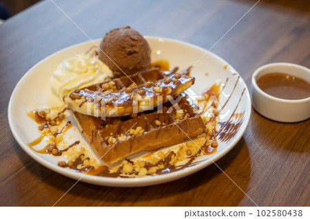 Chocolate waffle with ice cream served on plate Chocolate waffle with ice cream served on plate 102580438