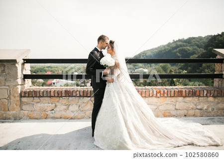 Sunshine portrait of happy bride and groom outdoor in nature location 102580860