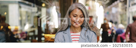 Happy mature lady working at city cafe Happy mature lady working at city cafe 102583035