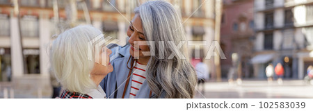 Enthusiastic women spending time together in city Enthusiastic women spending time together in city 102583039