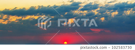 A celestial panorama at dawn. Red sun on the horizon, clouds, bright colors 102583730