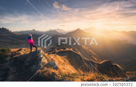 Young woman on mountain peak and beautiful mountain valley 102585372