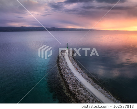 Aerial view of lighthouse on the pier at sunset in summer 102587818
