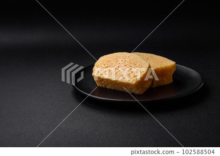 Delicious porous yellow cheese cut in large pieces on a ceramic plate Delicious porous yellow cheese cut in large pieces on a ceramic plate 102588504
