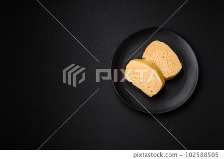 Delicious porous yellow cheese cut in large pieces on a ceramic plate Delicious porous yellow cheese cut in large pieces on a ceramic plate 102588505