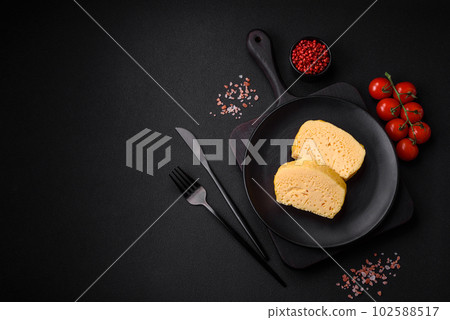 Delicious omelet with milk, spices and herbs cut into large pieces 102588517