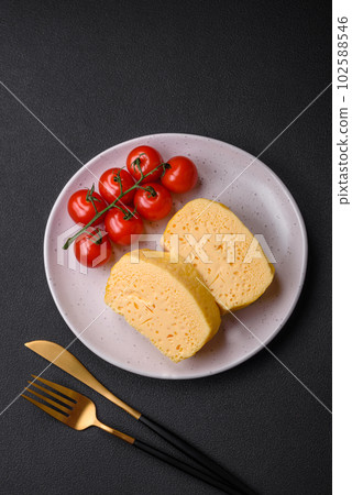 Delicious omelet with milk, spices and herbs cut into large pieces 102588546