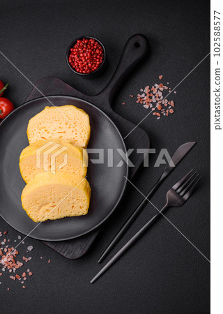 Delicious porous yellow cheese cut in large pieces on a ceramic plate Delicious porous yellow cheese cut in large pieces on a ceramic plate 102588577