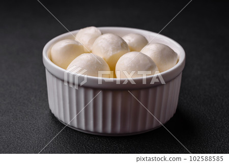 Delicious fresh mozzarella cheese in the form of small balls with salt and spices 102588585