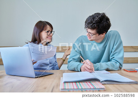 Young teenage male studying languages with teacher in classroom Young teenage male studying languages with teacher in classroom 102588598
