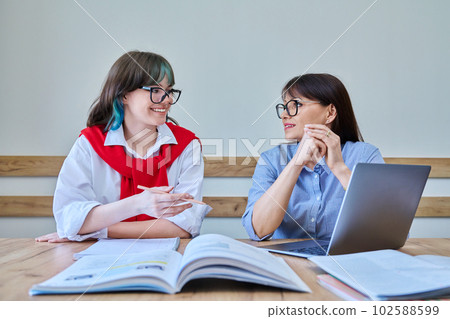 Young teenage female studying languages with teacher in classroom Young teenage female studying languages with teacher in classroom 102588599