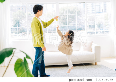 Parent and child playing in the living room 102595976