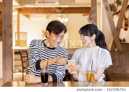 亞洲夫婦在咖啡館/咖啡店使用智能手機 亞洲夫婦在咖啡館/咖啡店使用智能手機 102596741
