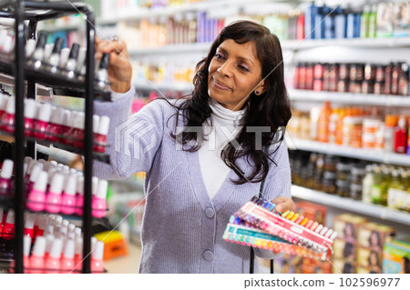 Indian woman selecting nail polish in supermarket 102596977