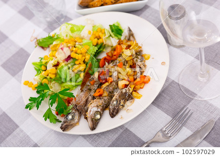 Fried blue whiting fish served with salad 102597029
