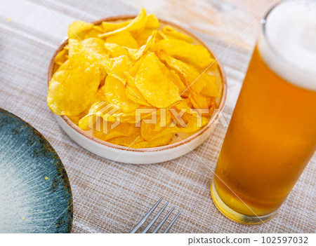 Chips served as snack food with beer Chips served as snack food with beer 102597032