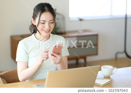 一位年輕女子單手操作智能手機 102597043