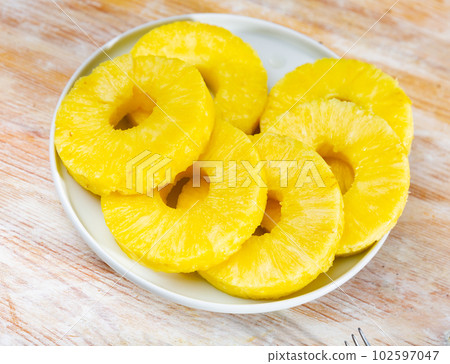 Ripe sliced pineapple on plate 102597047