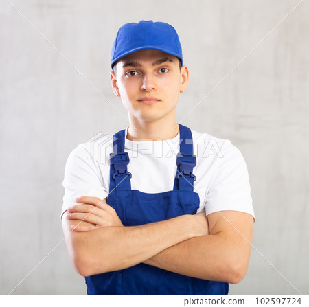 Portrait of positive smiling guy in blue protective overalls Portrait of positive smiling guy in blue protective overalls 102597724