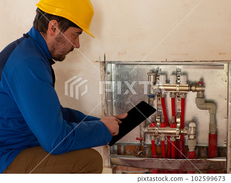 An employee adjusts the heating system via a tablet 102599673