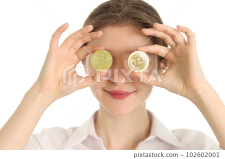 Woman holds golden coins with bitcoin symbol against eyes Woman holds golden coins with bitcoin symbol against eyes 102602001