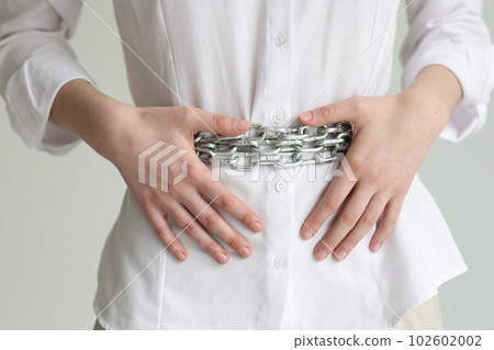 Woman with chain belt suffers from heaviness in stomach Woman with chain belt suffers from heaviness in stomach 102602002