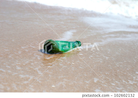 Green plastic bottle on the beach 102602132